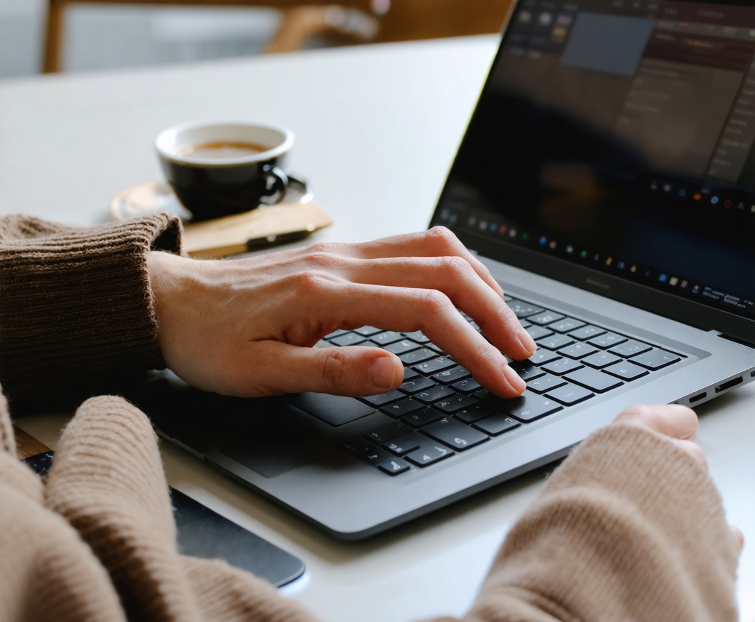 Ruky píšuce na notebooku v profesionálnom prostredí